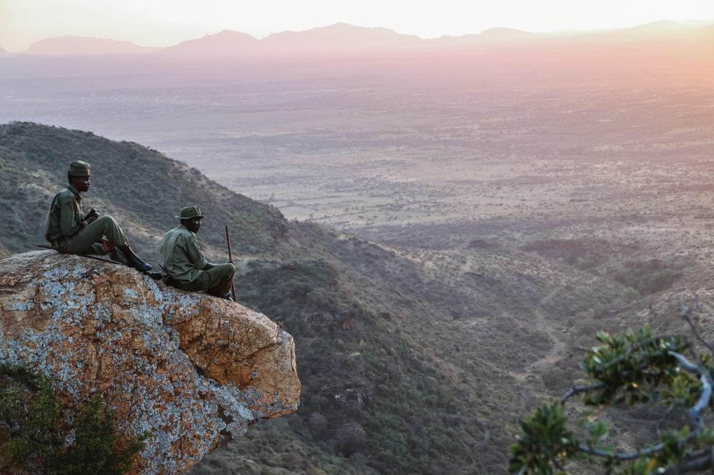 Rangers resting on a rocky outcrop at sunset